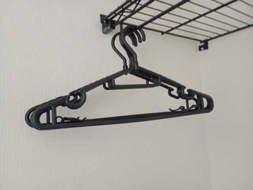 a black metal shelf hanging from a wall at 白熊ハウス in Wakayama