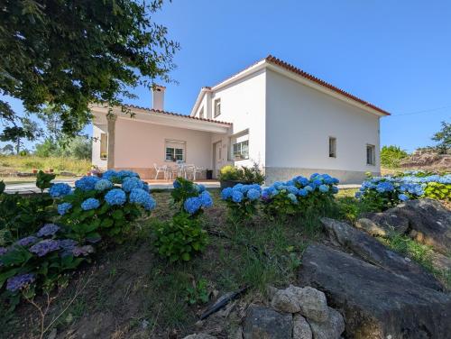 una casa con flores azules delante de ella en A casa da panadeira, en Cambados