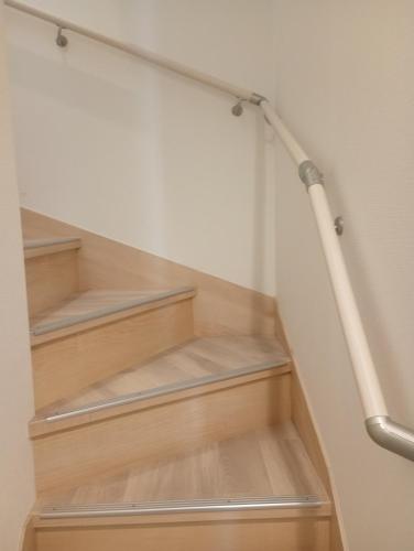 a stairwell with wooden shelves and a pipe at 白熊ハウス in Wakayama