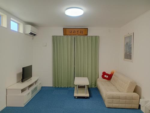 a living room with a couch and a tv at 白熊ハウス in Wakayama