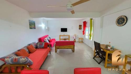 a living room with a red couch and a table at Maison de charme avec vue sur la mer à Sainte-Marie in Sainte-Marie