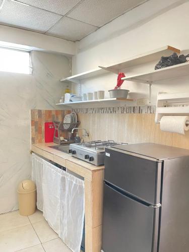 a kitchen with a stove and a refrigerator at SUIT PortoCentro1 in Portoviejo
