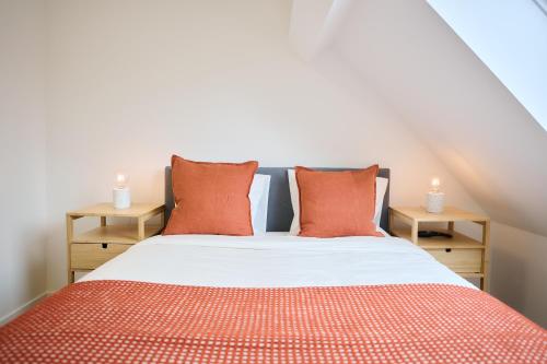 a bedroom with a bed with orange pillows at Apartment La Barrière 6 in Brussels