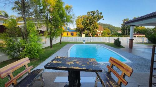 a table and two chairs next to a swimming pool at Villa D'Astana,A'Famosa Resort Pool-BBQ-Karaoke in Alor Gajah