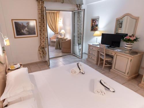 a bedroom with a bed and a desk with a mirror at Toscana Wellness Resort in Arcidosso
