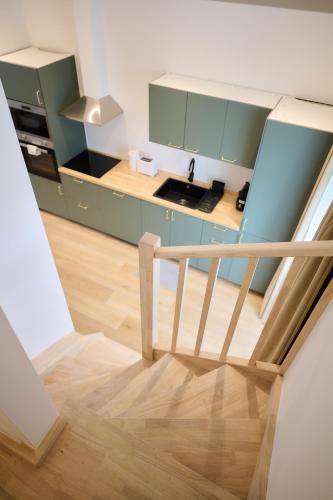 a kitchen with green cabinets and a wooden staircase at Apartment La Barrière 6 in Brussels