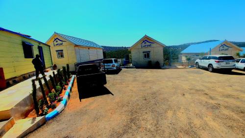 a man standing in a parking lot next to houses at اكواخ ارض الخير in Ajloun