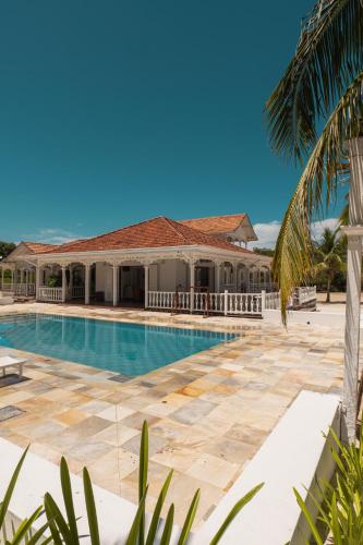 a swimming pool in front of a house at Hotel Agua Azul Beach Resort in Baru