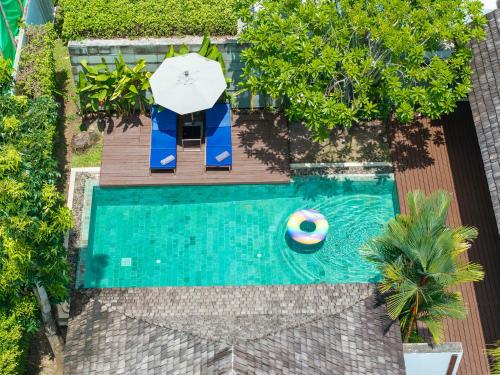 an overhead view of a swimming pool with an umbrella and a ball at BangTao Anchan 豪华两卧 私人泳池 现代度假巴厘风 in Layan Beach