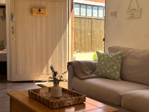 a living room with a couch and a table at The Smythy Cotswolds Farm Stay With Pool in Lechlade