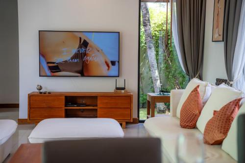 a living room with a couch and a tv at BangTao Anchan 豪华两卧 私人泳池 现代度假巴厘风 in Layan Beach