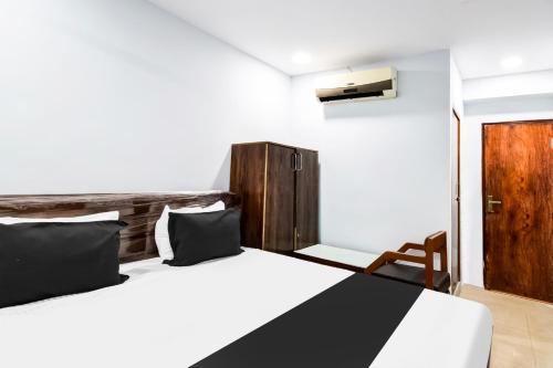 a bedroom with two beds and a wooden door at Hotel O ROYAL KAKATIYA in Maula Ali