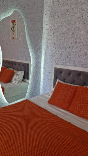 a bedroom with a bed with an orange blanket at Апартаменты в центре города Балхаш in Balqash