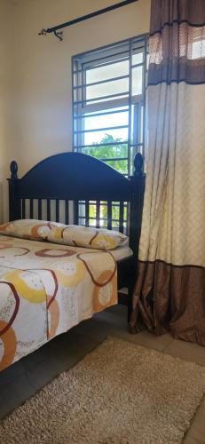 a bedroom with a bed and a window at Zuri Zen Villa in Dar es Salaam