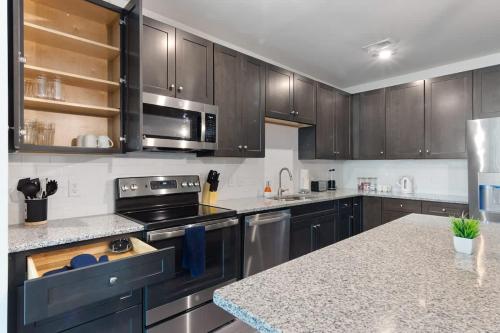 a kitchen with stainless steel appliances and wooden cabinets at Luxe King 2 Bedroom Suite in North Raleigh in Wake Forest