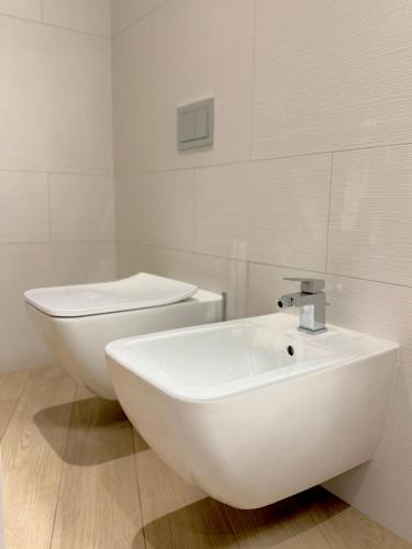 a white bathroom with a sink and a toilet at Condo Studio Plaza in Budva