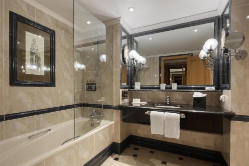 a bathroom with a tub and a sink and a mirror at Dom Pedro Lisboa Hotel, a member of Radisson Individuals in Lisbon