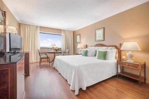 a hotel room with a bed and a television at Dom Pedro Lisboa Hotel, a member of Radisson Individuals in Lisbon