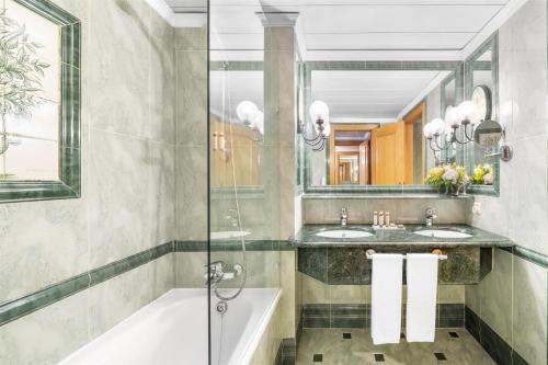 a bathroom with two sinks and a tub and a shower at Dom Pedro Lisboa Hotel, a member of Radisson Individuals in Lisbon