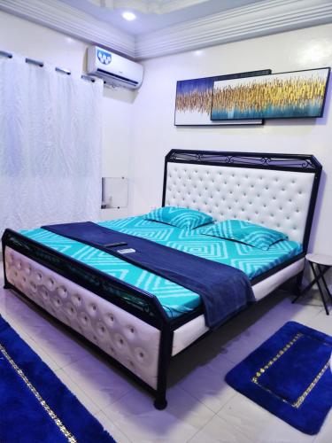 une chambre avec un lit avec une couette bleue dans l'établissement Mini Studio tres chic, à Dakar