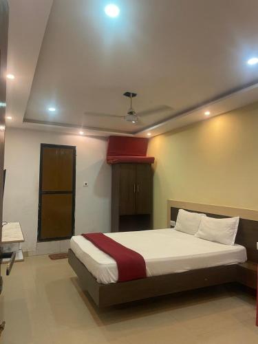 a bedroom with a large bed with a red blanket at hotel Nirvana in Calangute
