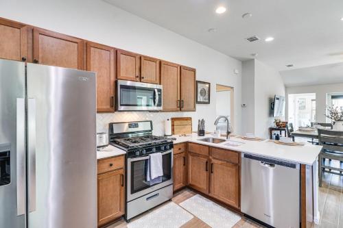 a kitchen with wooden cabinets and a stainless steel refrigerator at Pool Access and Private Yard Family Home in Kyle! in Kyle