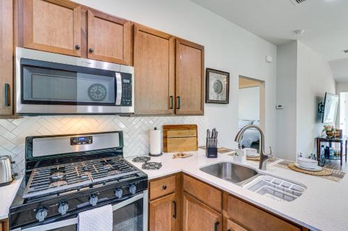 a kitchen with a stove and a sink and a microwave at Pool Access and Private Yard Family Home in Kyle! in Kyle