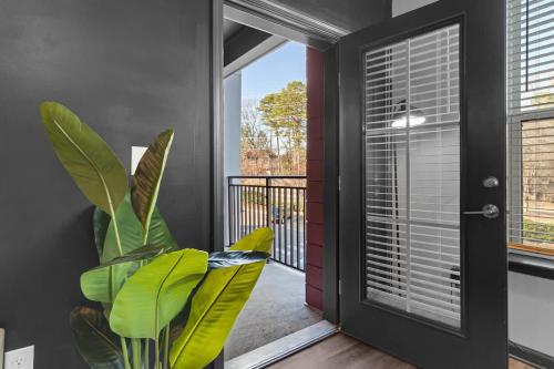 a room with a plant next to a door at Luxe King 3BR Suite North Raleigh in Wake Forest