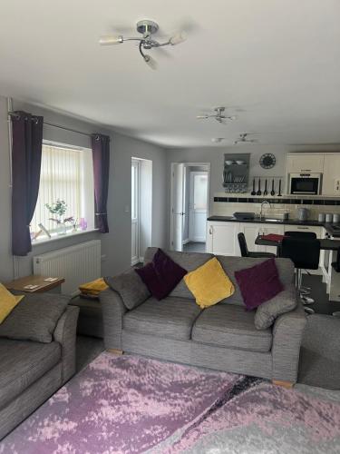 a living room with a couch and a kitchen at 2 bedroom bungalow, 15 minutes to Alton Towers, dog friendly in Wetleyrocks