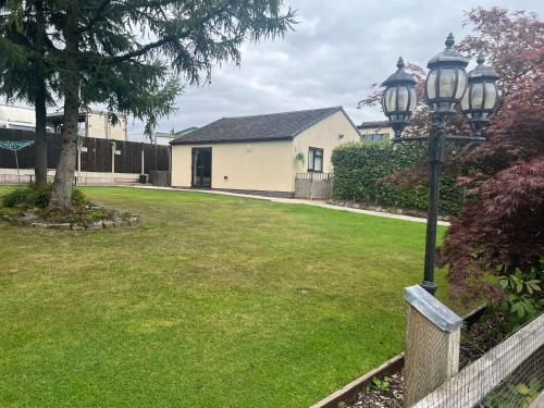 a street light in a yard with a house at 2 bedroom bungalow, 15 minutes to Alton Towers, dog friendly in Wetleyrocks