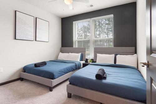 ウェイクフォレストにあるLuxe King 3 Bedroom Suite in North Raleigh NCのベッド2台と窓のある寝室