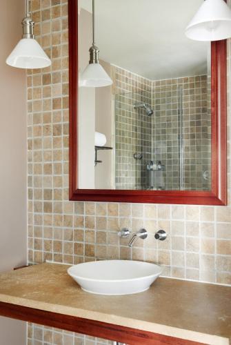 a bathroom with a sink and a mirror at The Harbor Front Inn in Greenport