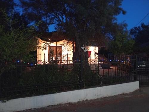 a house behind a fence at night with lights at Lefkas house with garden in Tsoukaladhes