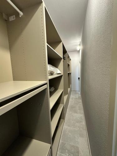 a walk in closet with empty shelves and a hallway at Casa in mezzo agli Ulivi in Lamporecchio