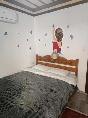 ein Schlafzimmer mit einem Bett mit einer Meerjungfrau an der Wand in der Unterkunft Şirince Larin Pansiyon in Selçuk