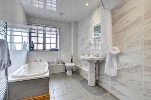 a bathroom with a tub and a sink and a toilet at Yr Efail in Y Felinheli