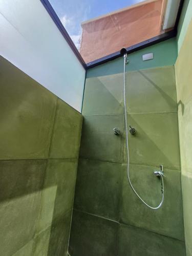 a shower with a hose in a green bathroom at Fraga da Mantiqueira in São Bento do Sapucaí