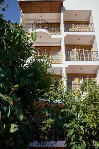 a white building with trees in front of it at Maimara Hotel in Huaraz