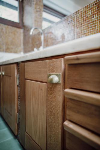 a kitchen with wooden cabinets and a sink at Casa d'Abreu Neto - Siza's First Work in Matosinhos