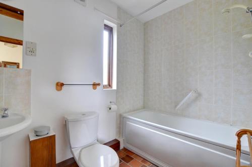 Un baño con bañera, inodoro y lavabo. en Shippon, en Walton West
