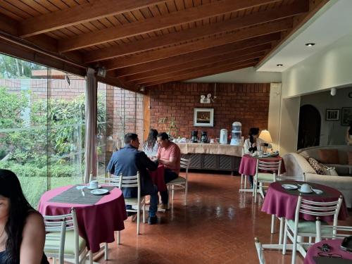 a group of people sitting at tables in a restaurant at Villas Del Sol Bed & Breakfast in Lima