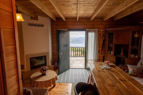 a living room with a wooden table and a sliding glass door at House of Dragkol in Kastaniá