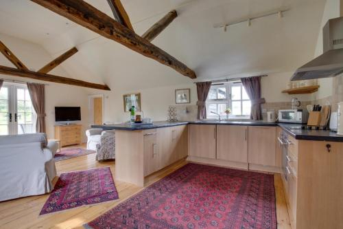 eine große Küche mit Holzschränken und einem roten Teppich in der Unterkunft Pound Hill Cottage in Frittenden