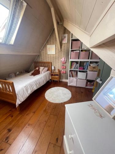 a attic bedroom with a bed and a rug at La campagne à Paris in Bagnolet