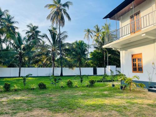 a view of a house with palm trees in the background at Nachchi Sweet Beach Stay in Nilaveli