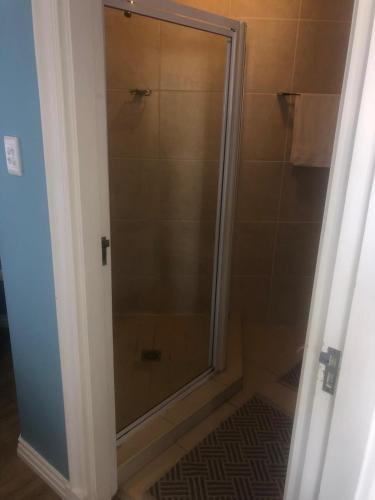 a shower with a glass door in a bathroom at Palmsbeach 5 in Strand