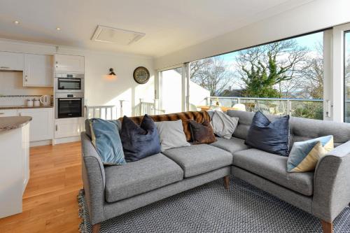 a living room with a gray couch with blue pillows at 1 Glyn Y Marian in Llanbedrog