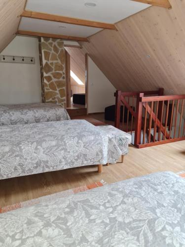 a bedroom with two beds and a staircase at Hiiemäe Puhkemaja in Kunda