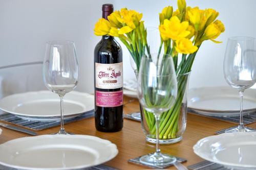 a bottle of wine sitting on a table with yellow flowers at 1 Glyn Y Marian in Llanbedrog