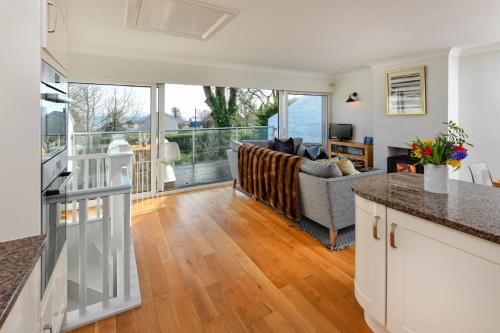 a kitchen and living room with a couch at 1 Glyn Y Marian in Llanbedrog